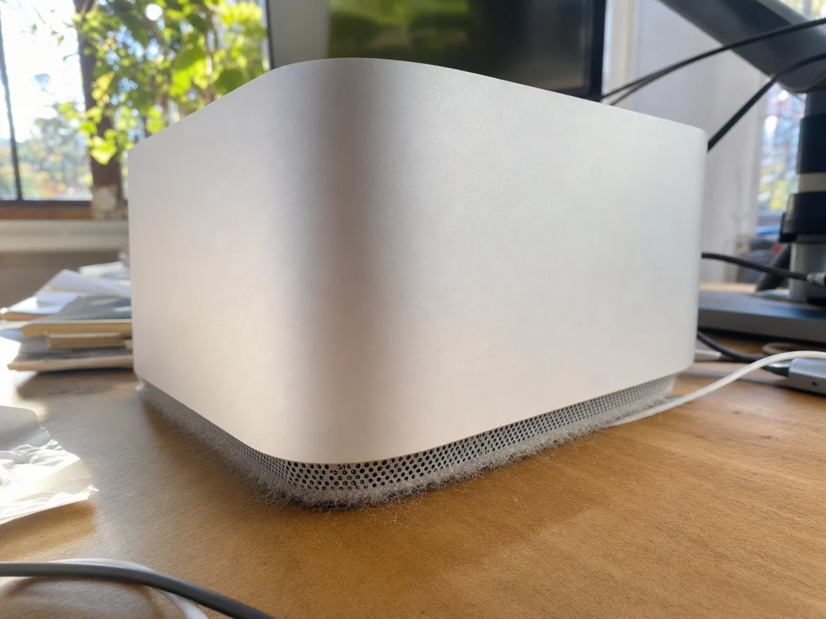 Mac Studio running hot on a desk with dust around the base, a common sign it needs Mac Studio cleaning and thermal paste replacement